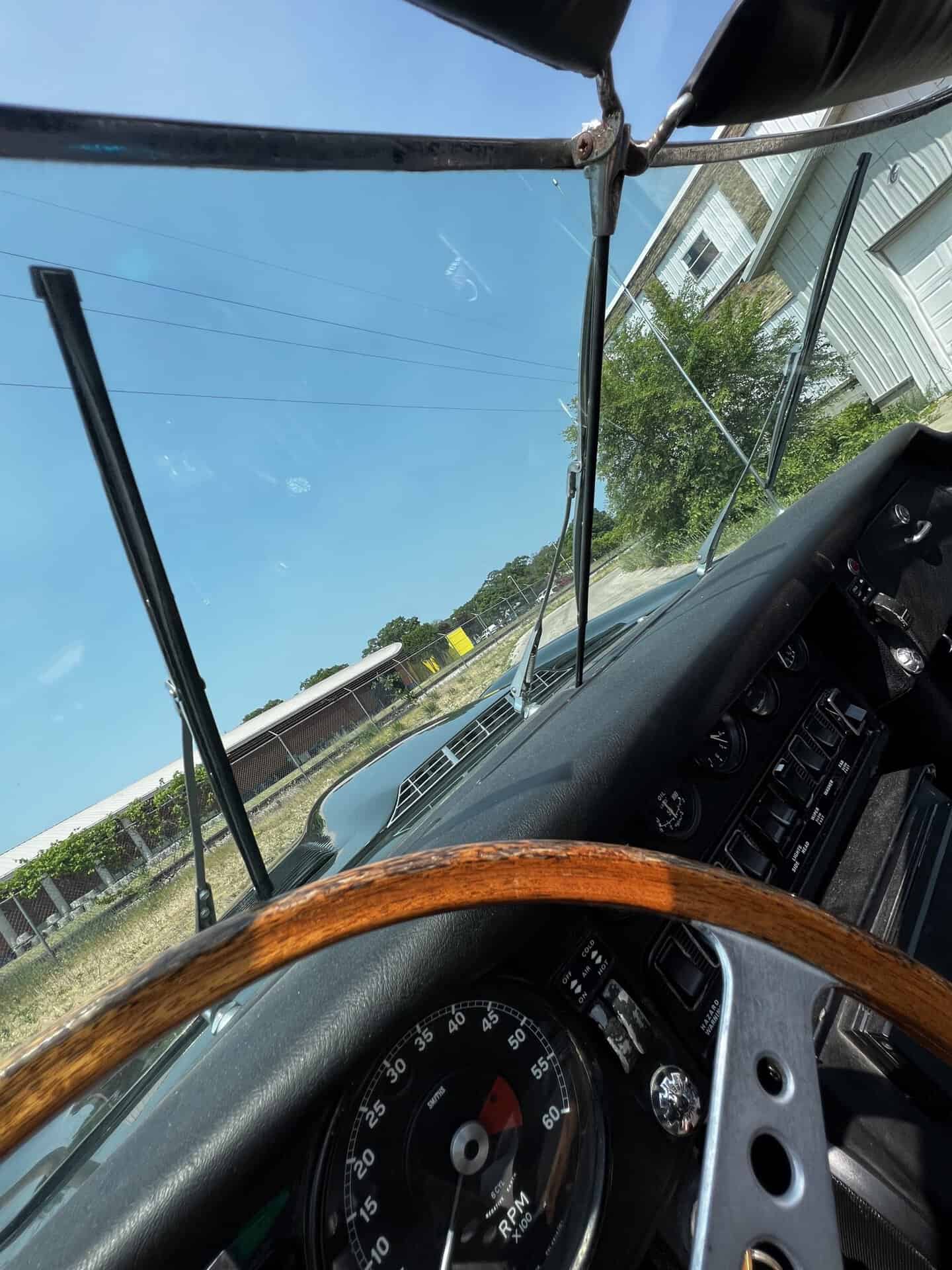 View of a truck's dashboard and windshield with a clear blue sky.