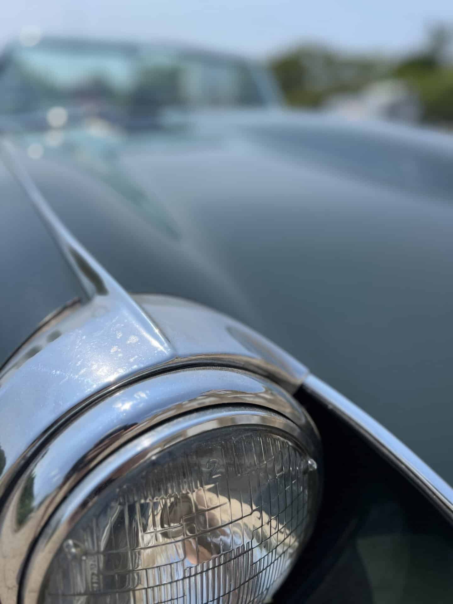 Close-up of the vintage Jaguar E-Type headlight and front fender.