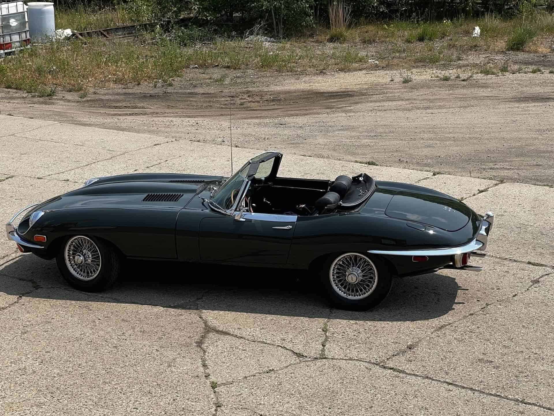 Classic 1970 Jaguar E-Type convertible with black exterior and open top.