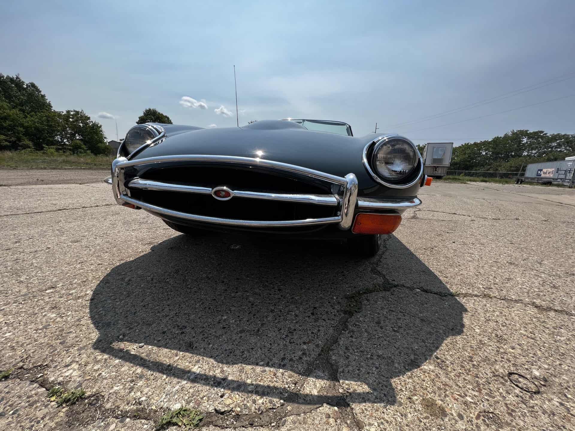 Vintage 1970 Jaguar E-Type sports car in black on pavement.