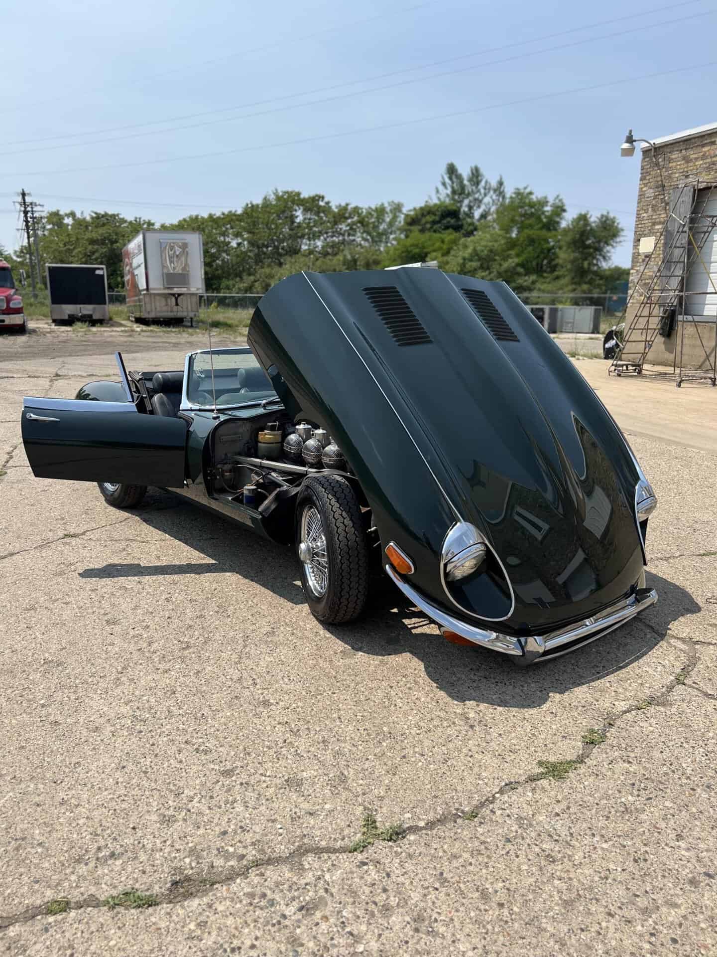 Black vintage convertible with hood open at All Speed Customs.