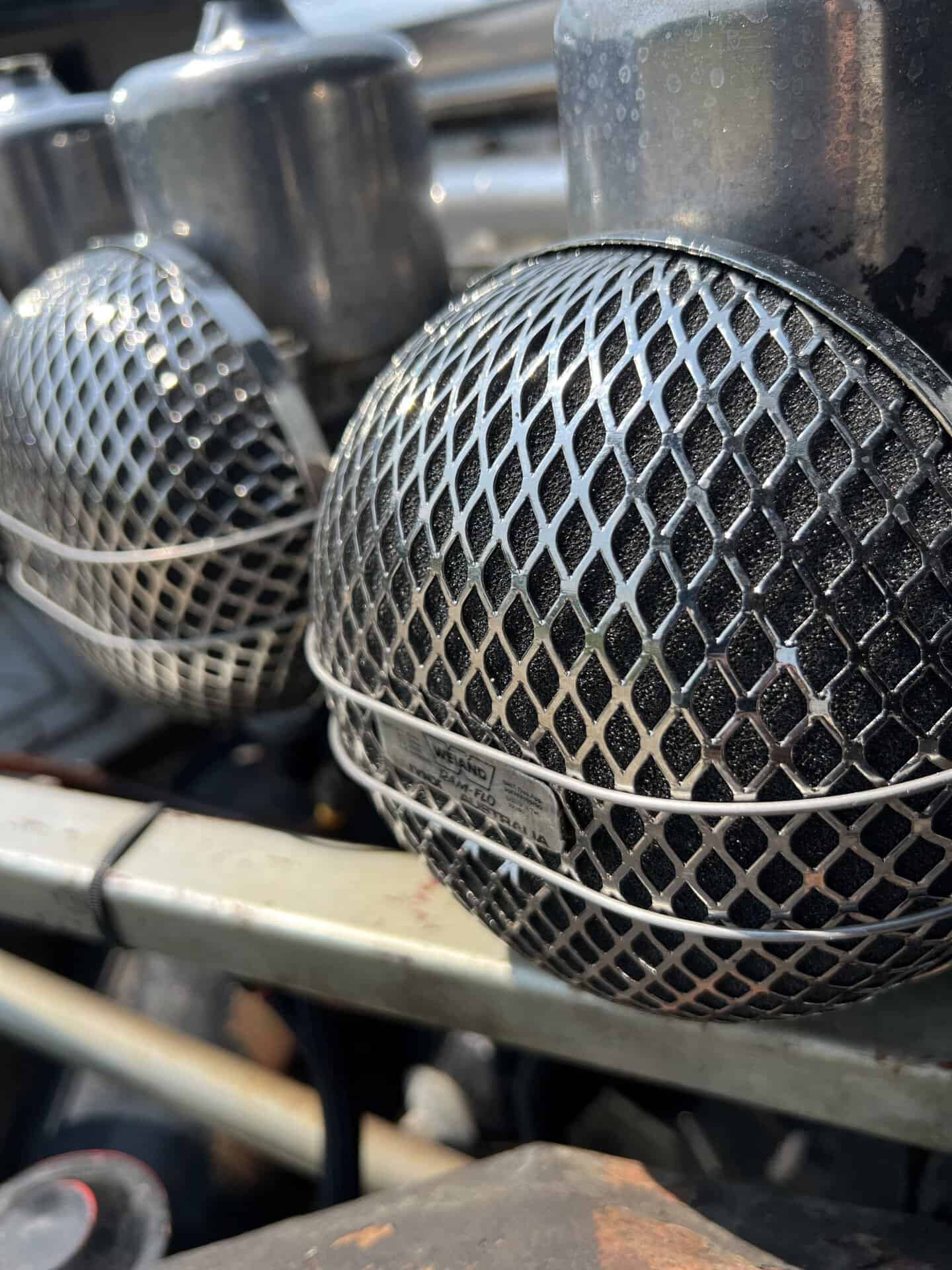 Close-up of custom car headlights with protective mesh covers.