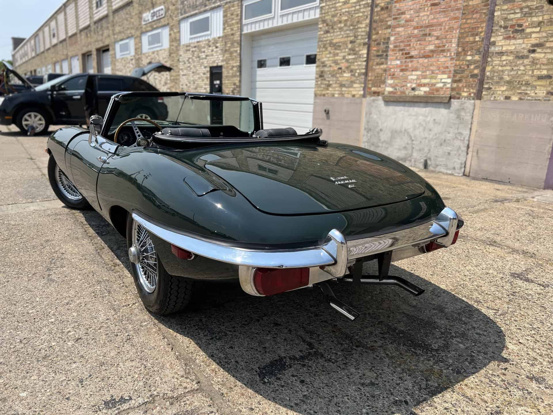 Vintage 1970 Jaguar E-Type convertible parked on street.