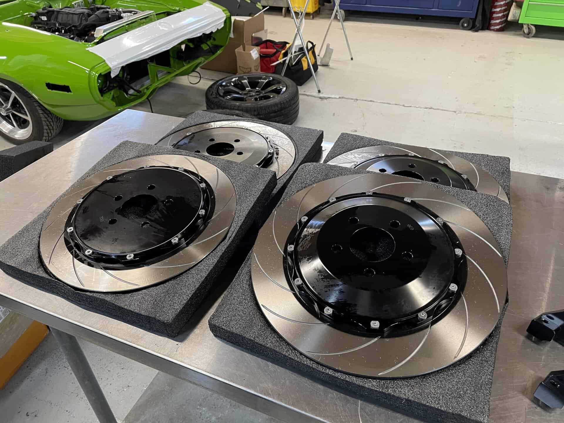 High-performance wheel parts on foam pads in workshop.