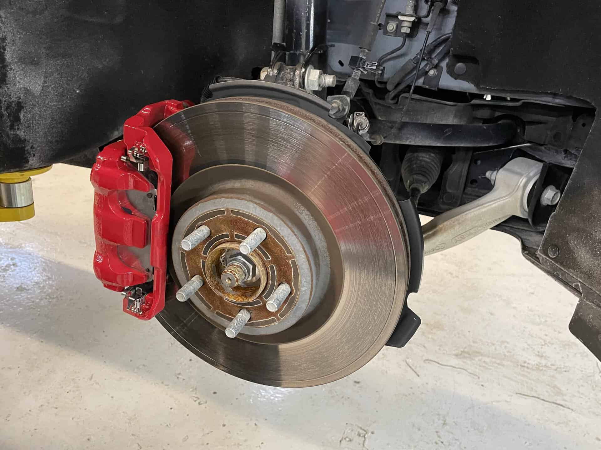 Close-up of Ford Explorer Sport brake rotor and red caliper.