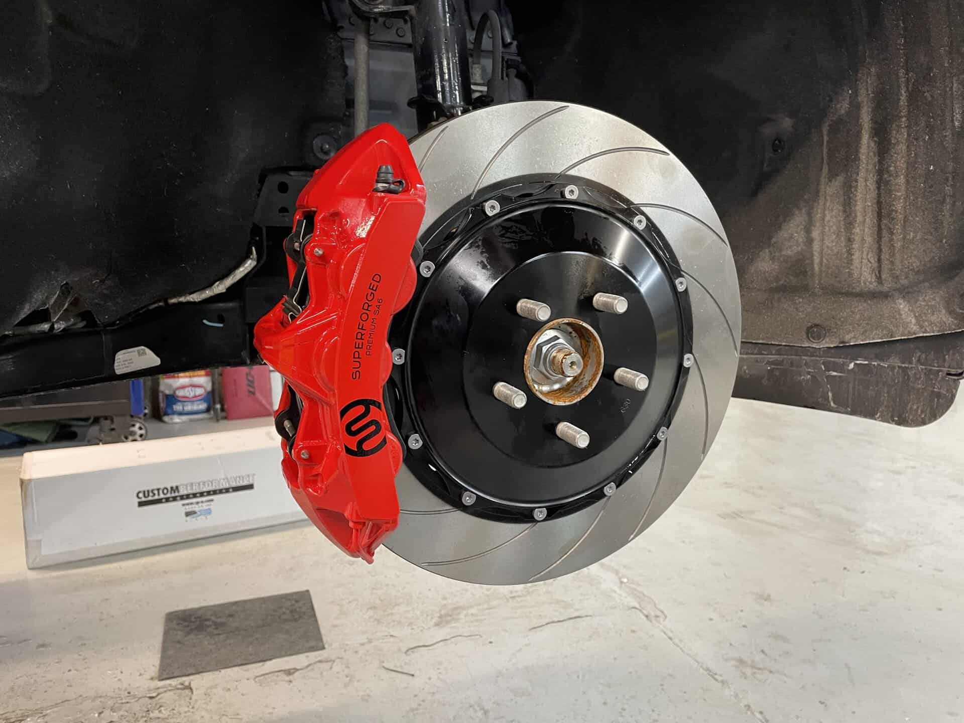 High-performance brake rotor and red caliper on a Ford Explorer Sport.