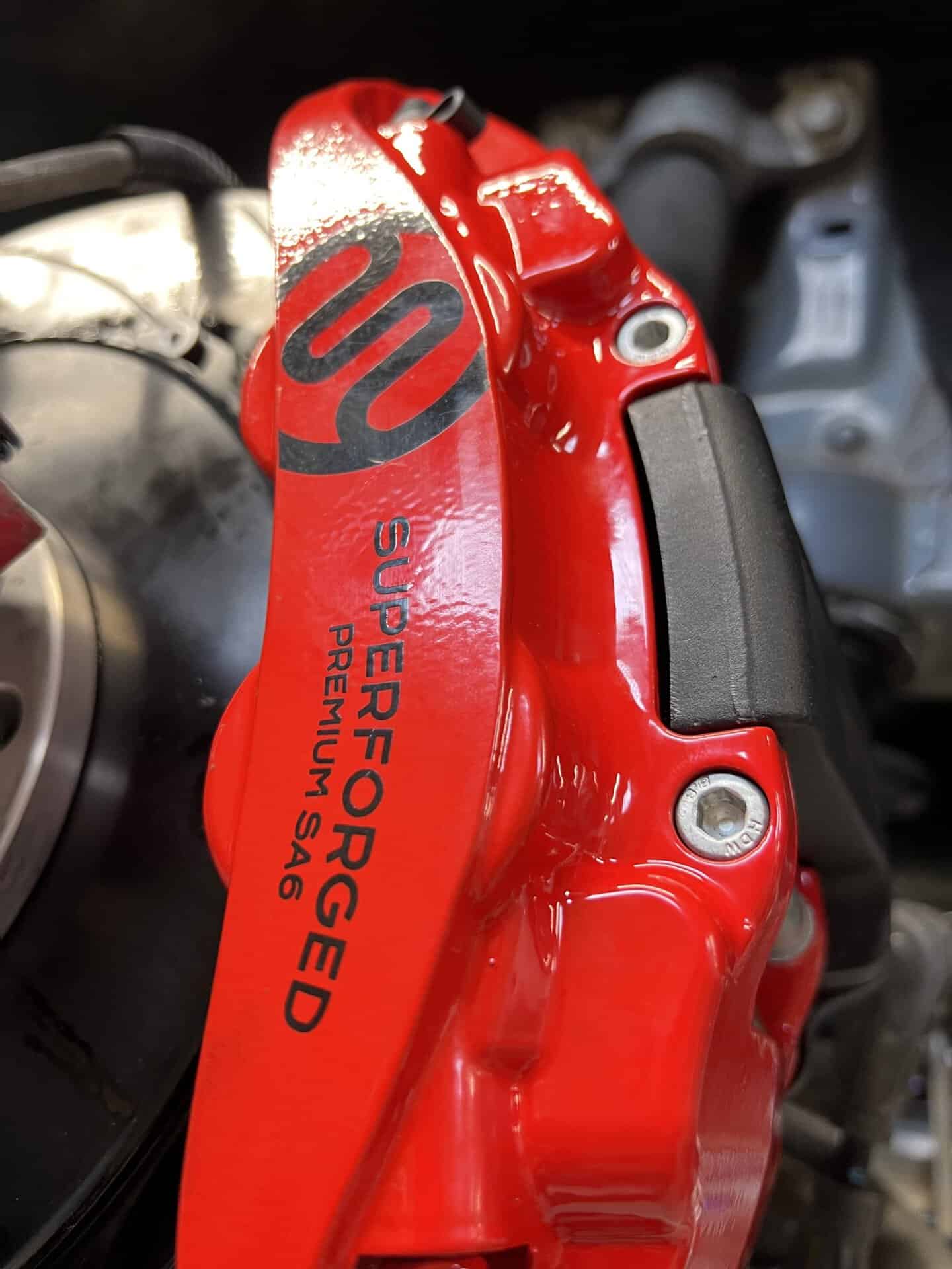 Red brake caliper with All Speed Customs logo and Superformance branding.