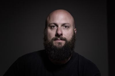 Close-up portrait of a man with a beard and bald head.