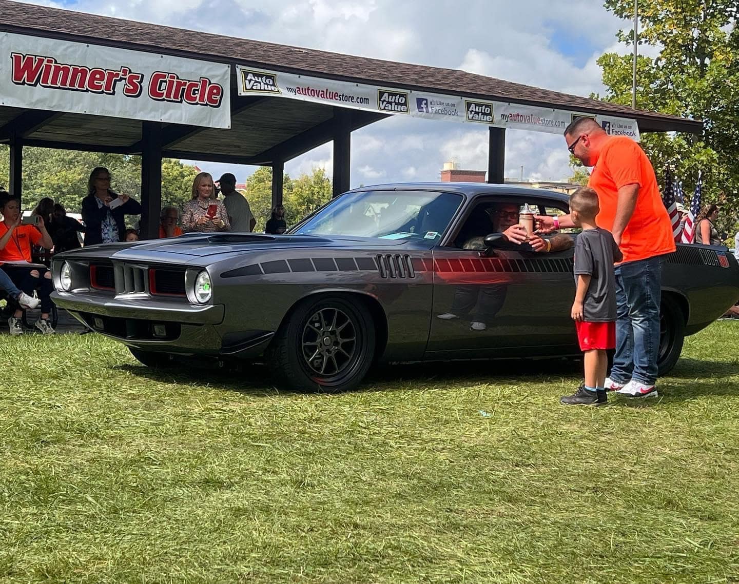 Black classic muscle car at Frankenmuth Auto Fest 2023 with people around.