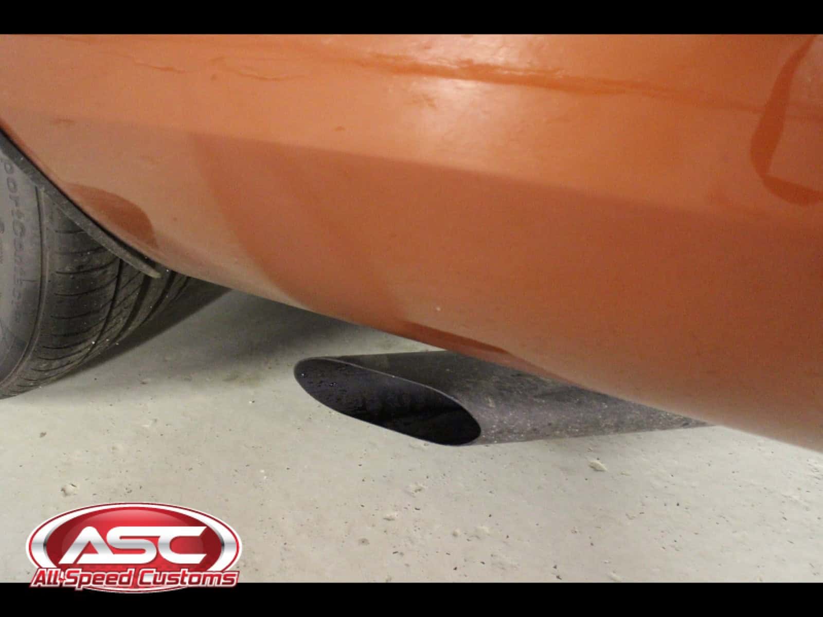 Close-up of custom exhaust pipe under a 1968 Dodge Charger.