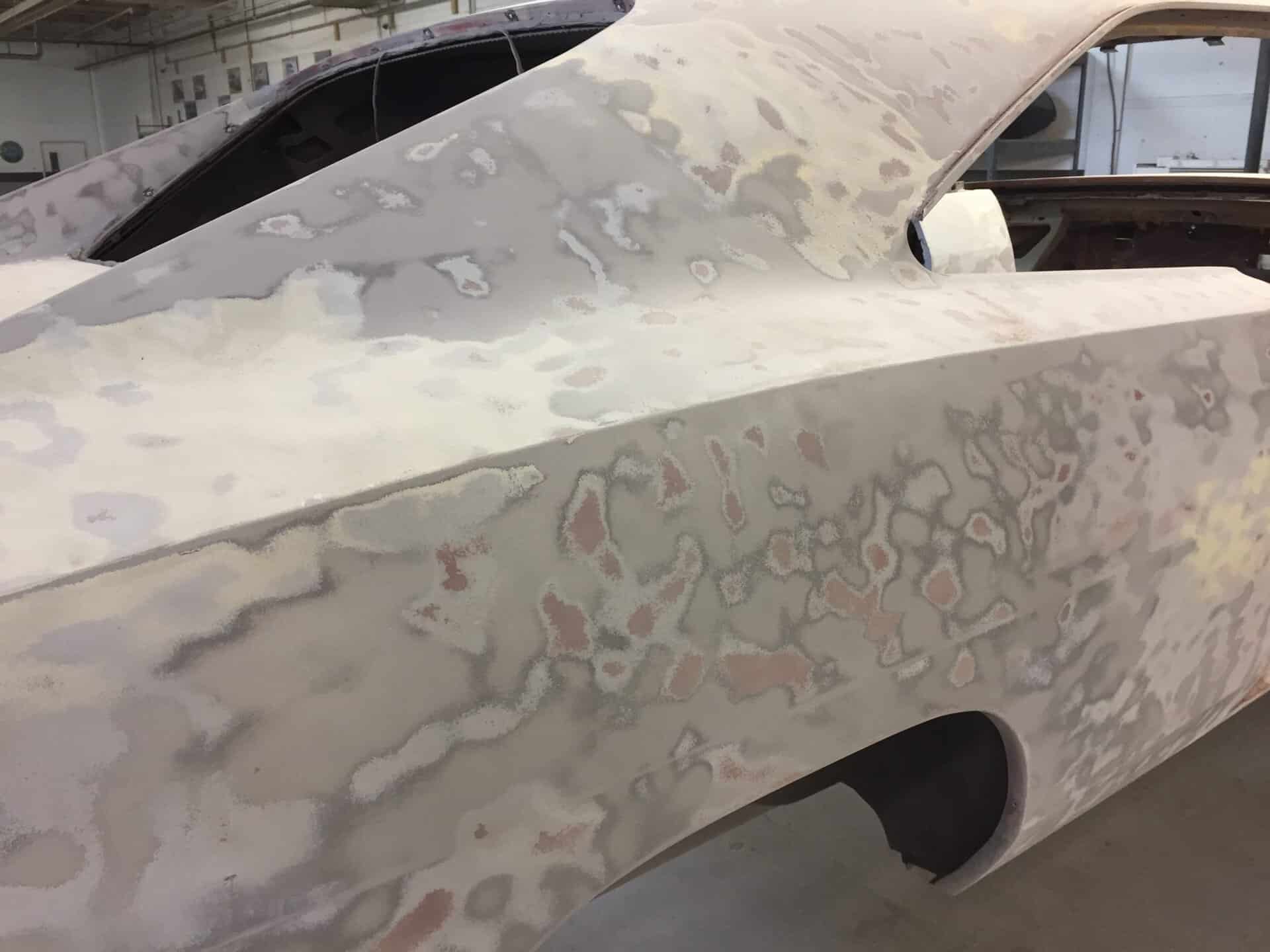 Classic 1968 Dodge Charger in restoration process with primer and bodywork visible.