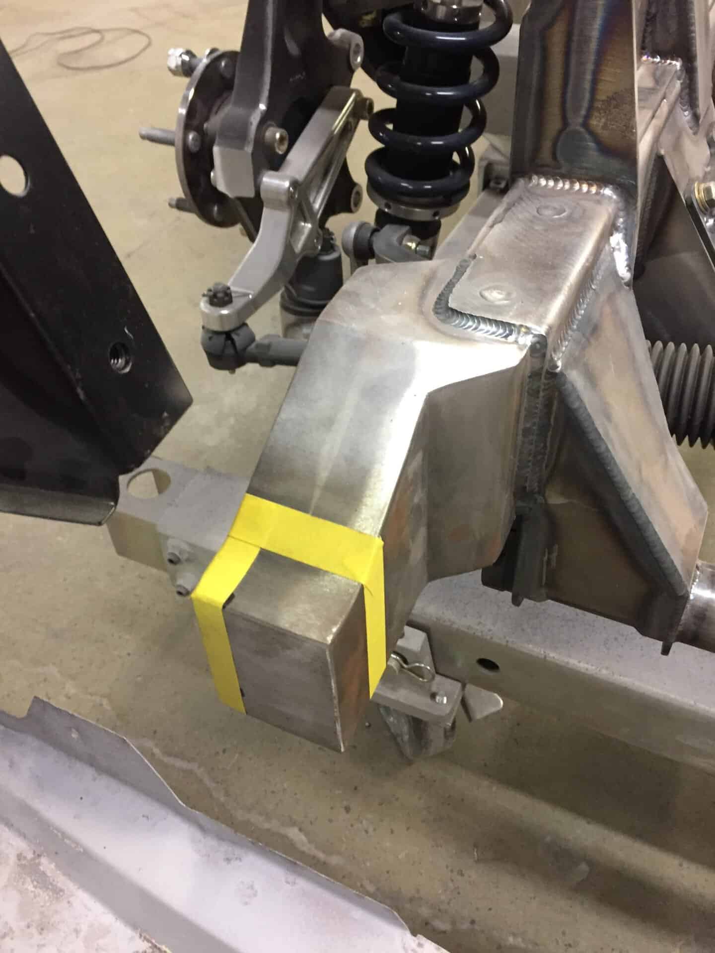 Close-up of custom suspension part with coil spring and metal bracket.