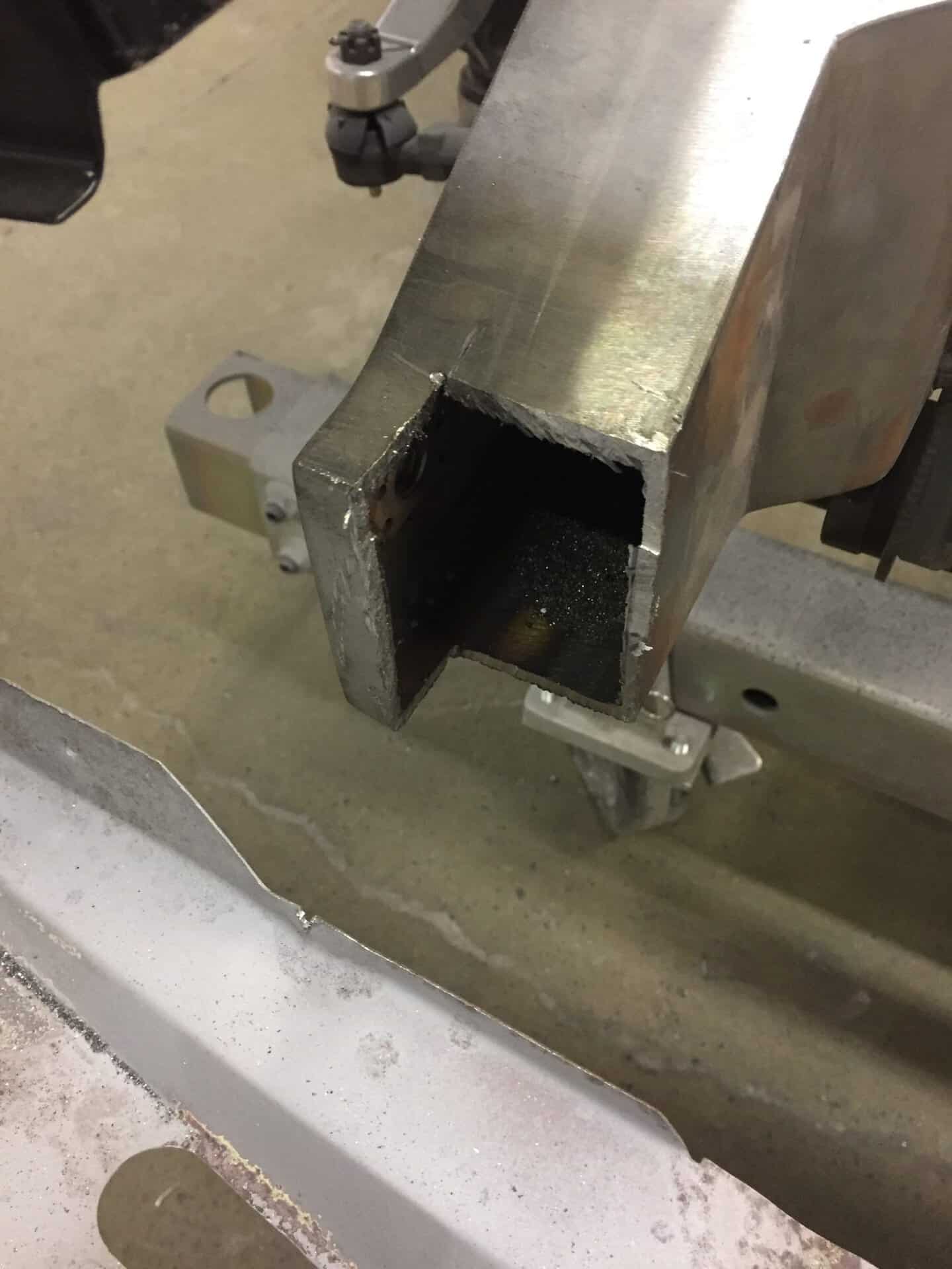 Metal frame with hollow square section for car modification or repair.