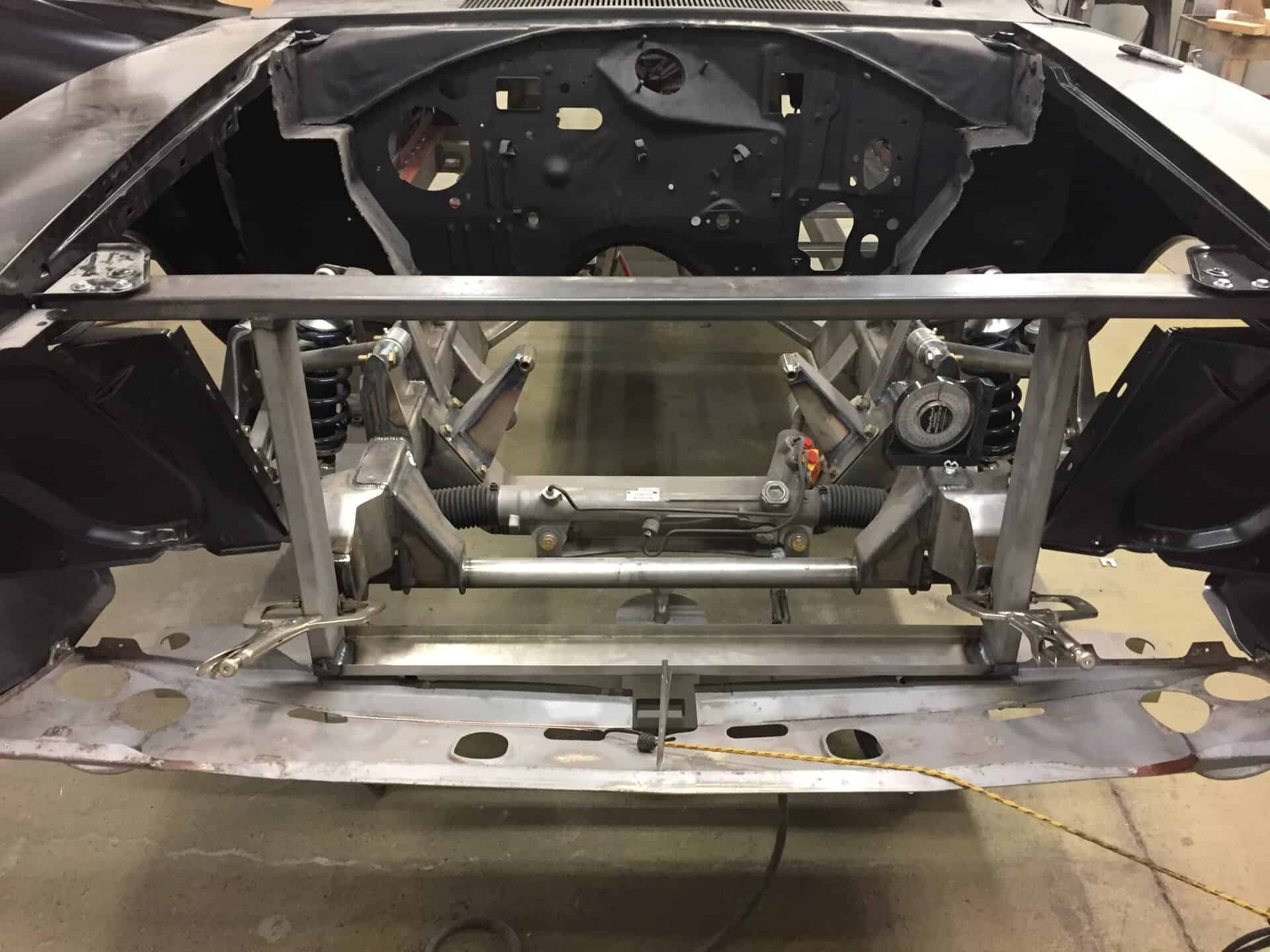 Car frame and chassis being restored at All Speed Customs workshop.