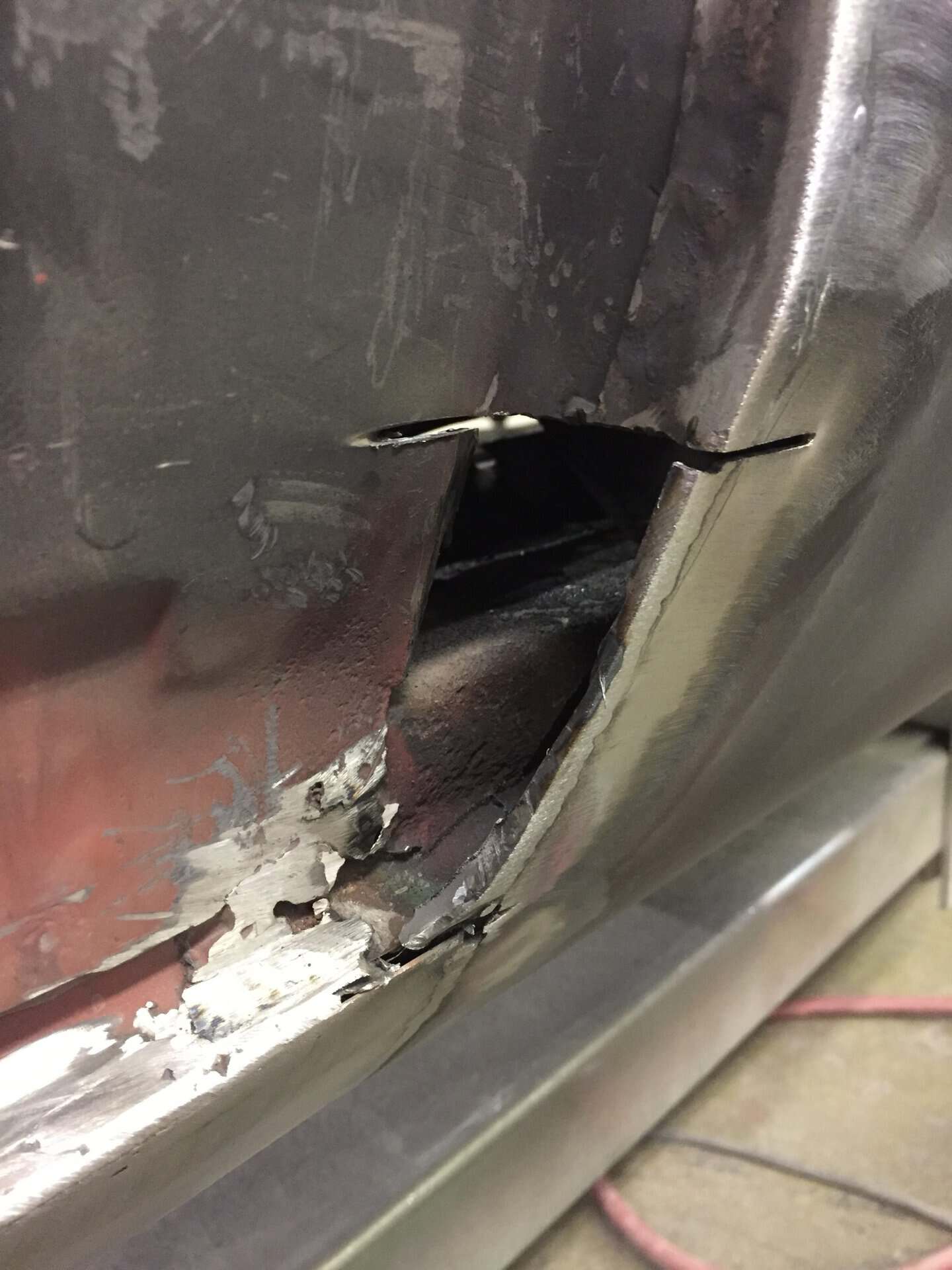 Close-up of car body damage and rust repair on a 1968 Dodge Charger.