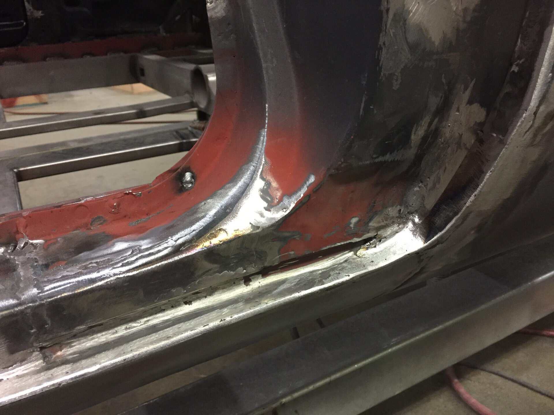 Close-up of car door frame with welding and metalwork in progress.