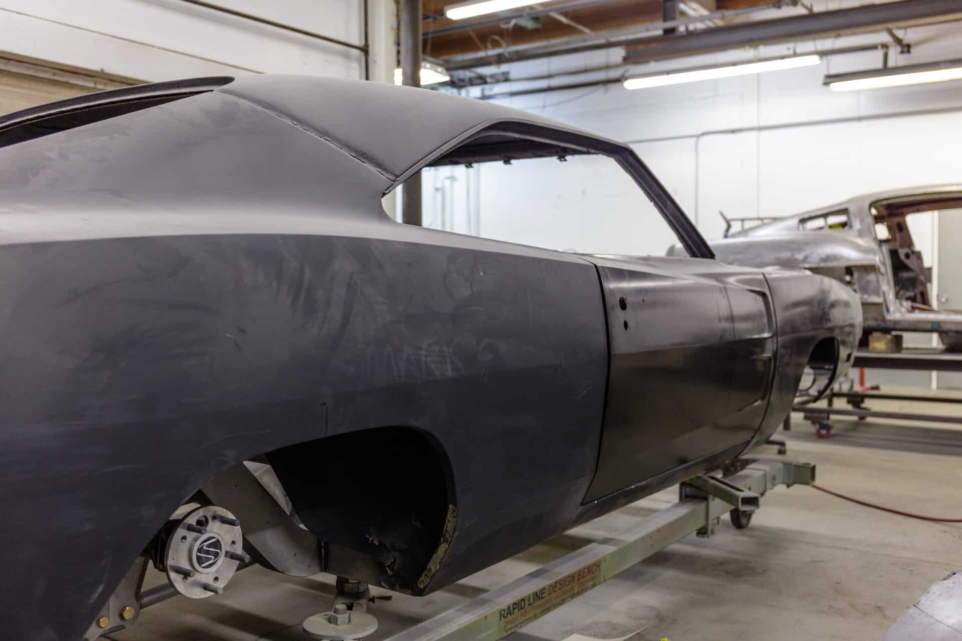 Unfinished 1968 Dodge Charger in workshop with black primer paint.
