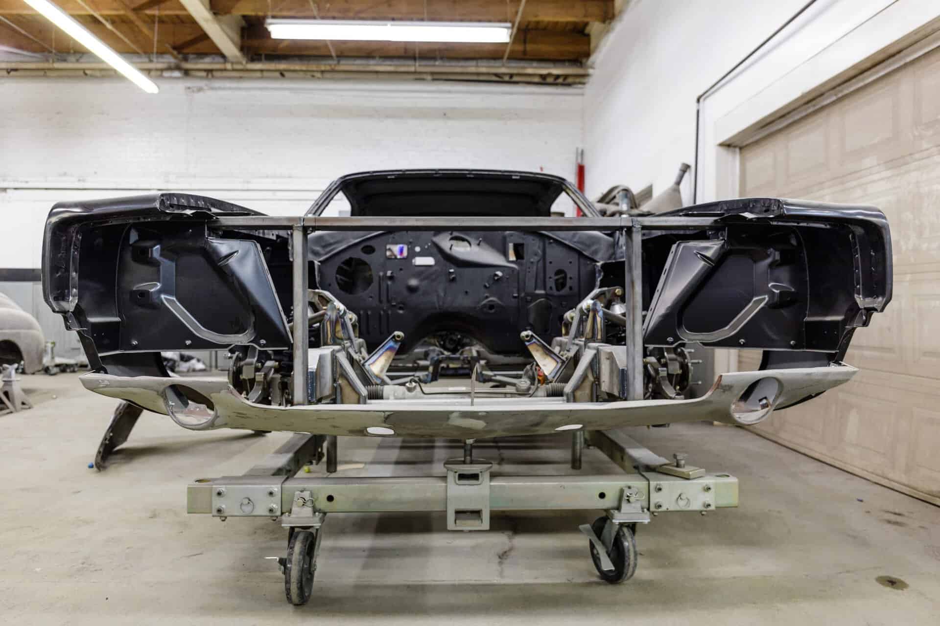 Bare frame of a 1968 Dodge Charger in a workshop setting.