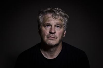 Portrait of a man with blonde hair and a serious expression.