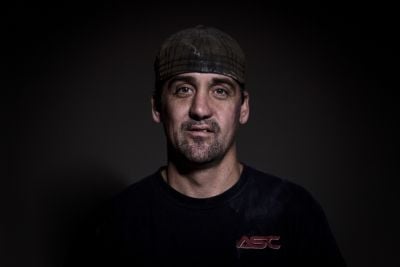 Portrait of Jonathan Vannord with dark background and casual attire.