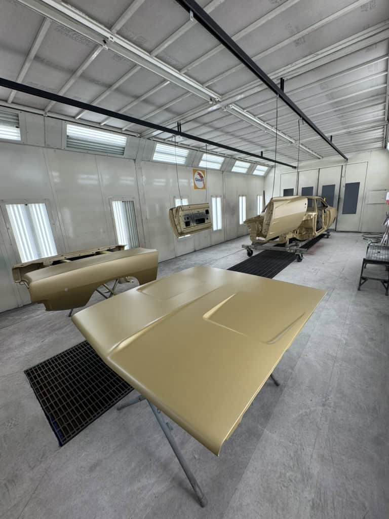 Auto body parts in a spray booth at All Speed Customs.
