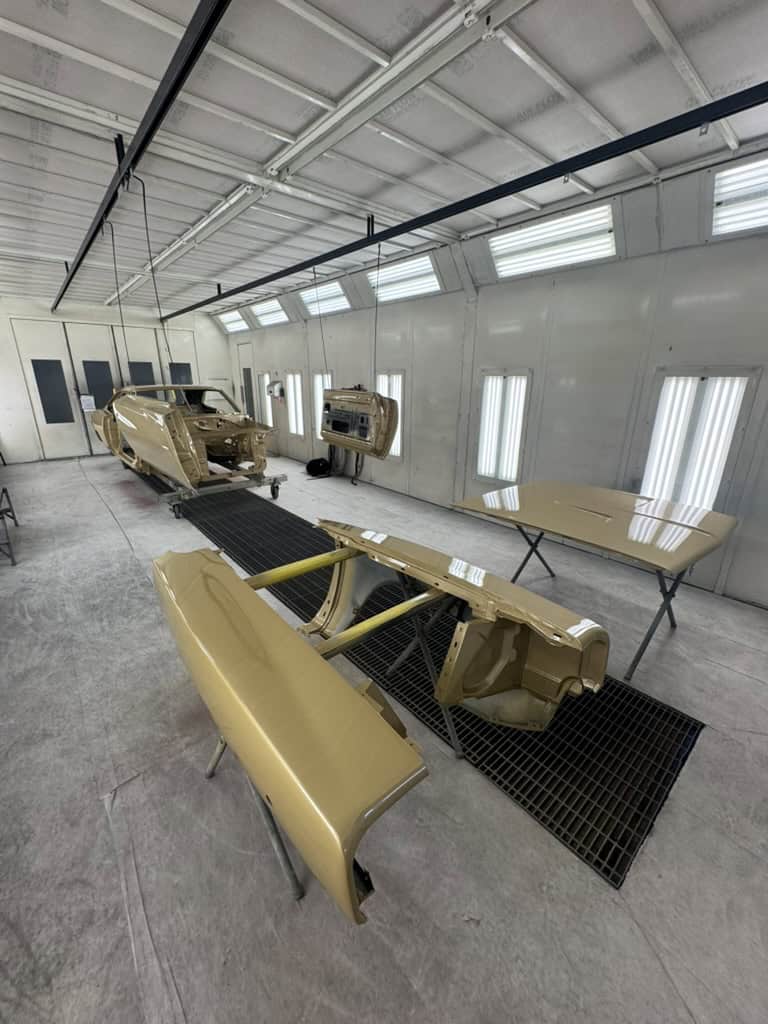 Car body parts in a paint booth at All Speed Customs.
