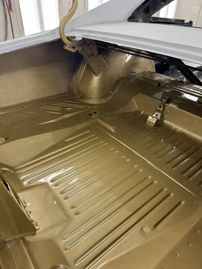 Clean, restored car trunk with gold paint and detailed metalwork.