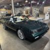 Black convertible classic car inside All Speed Customs showroom, automotive restoration and customization.