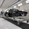 Black 1979 Pontiac Trans Am body shell in a workshop.