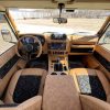 Interior view of a customized luxury RV with wood accents and modern dashboard.