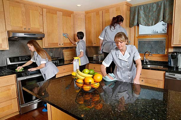 A team of professional cleaners busy at work on a clients kitchen.