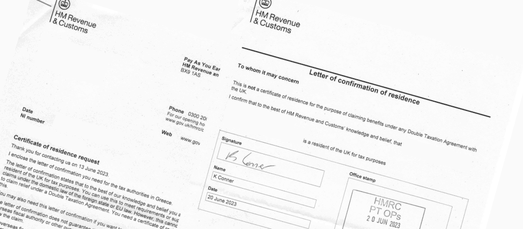 Two people are exchanging documents in an office setting, with a computer and pens visible on the table.
