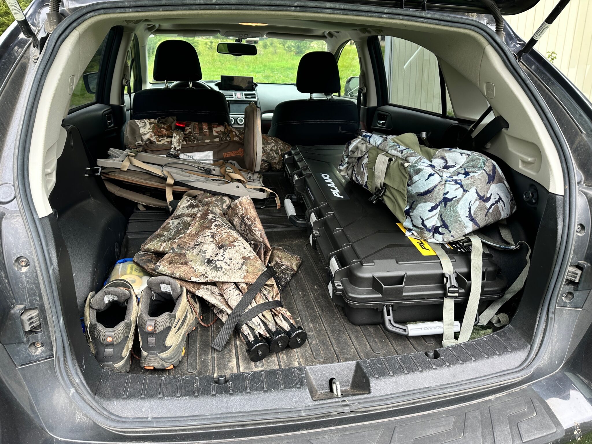 Bowhunting gear and bow case arranged in a vehicle