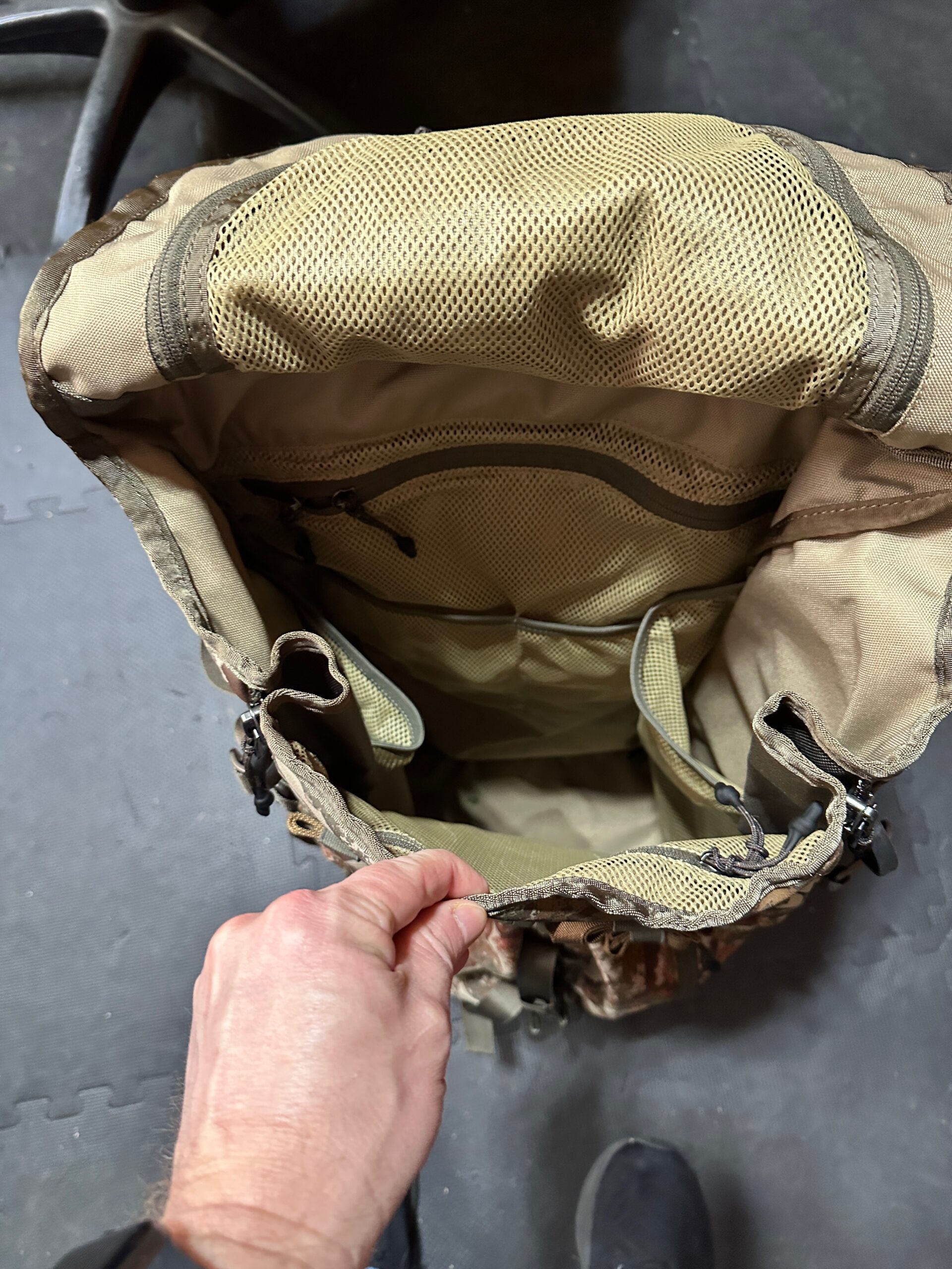 Inside the First Lite Transfer Pack showing mesh organization pockets and open bucket-style main compartment