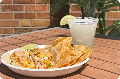 Outdoor rooftop dining with delicious tacos and refreshing margarita.