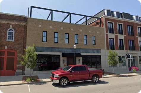 Rooftop view of Attwood's Kitchen & Drink with outdoor seating and cityscape backdrop.