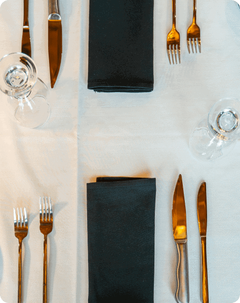 Elegant table setting with gold cutlery and black napkins for Attwood's Kitchen & Drink.