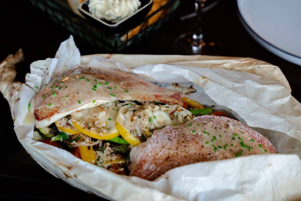 Delicious fish tacos with fresh vegetables, spices, and herbs served in a casual dining setting.