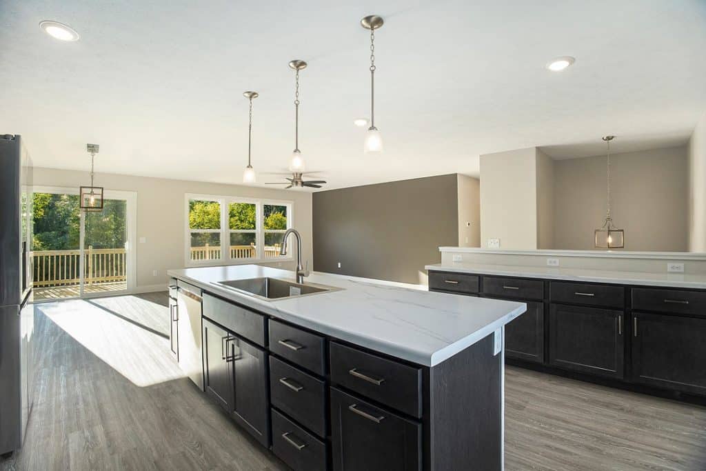 Spacious modern kitchen with island, black cabinets, and large windows.