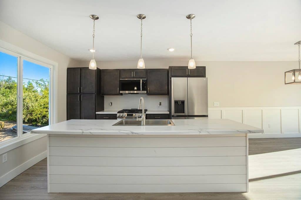 Contemporary kitchen with island, dark cabinets, and large windows for natural light.