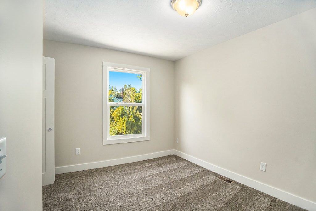 Empty room with window and neutral walls in a BuildWest home.