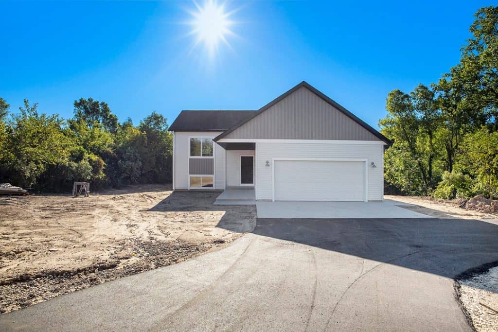 Newly built modern home with white exterior and attached garage.