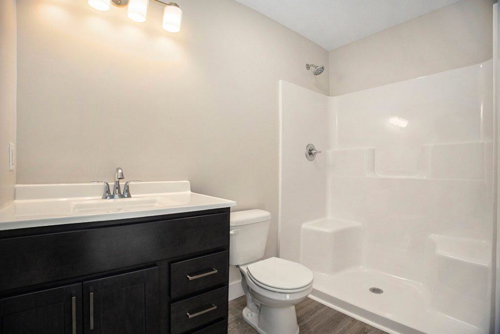 Contemporary bathroom with shower, toilet, and vanity in new home.