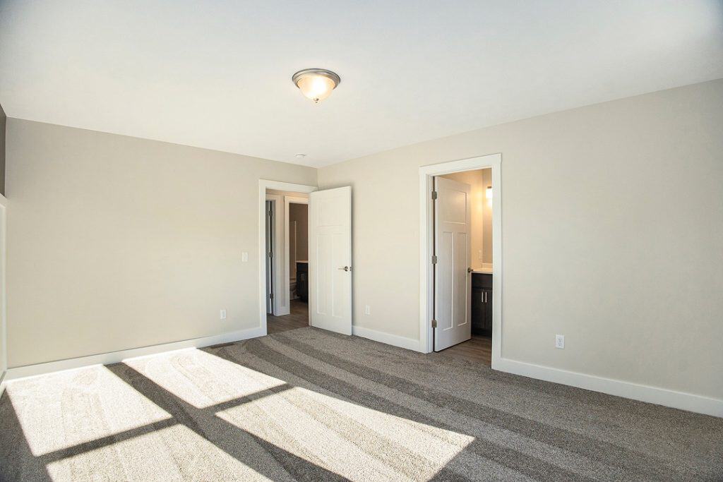 Bright and spacious bedroom with natural light and neutral decor.