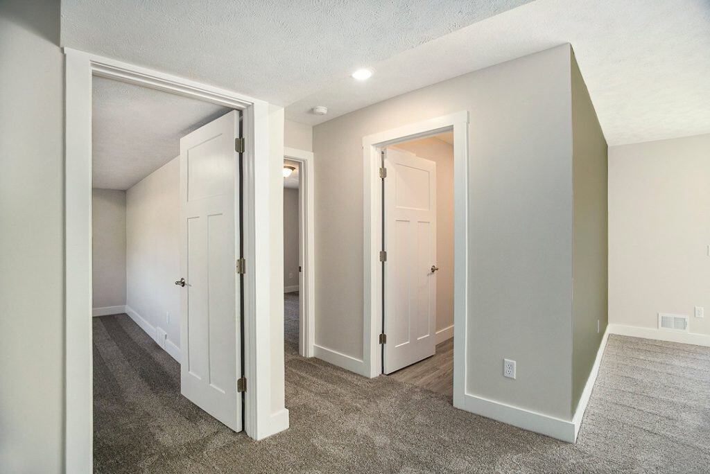 Interior view of a new BuildWest Custom Home with white walls and gray carpet.