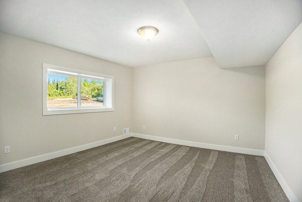 Bright empty room with window and neutral walls in new home.