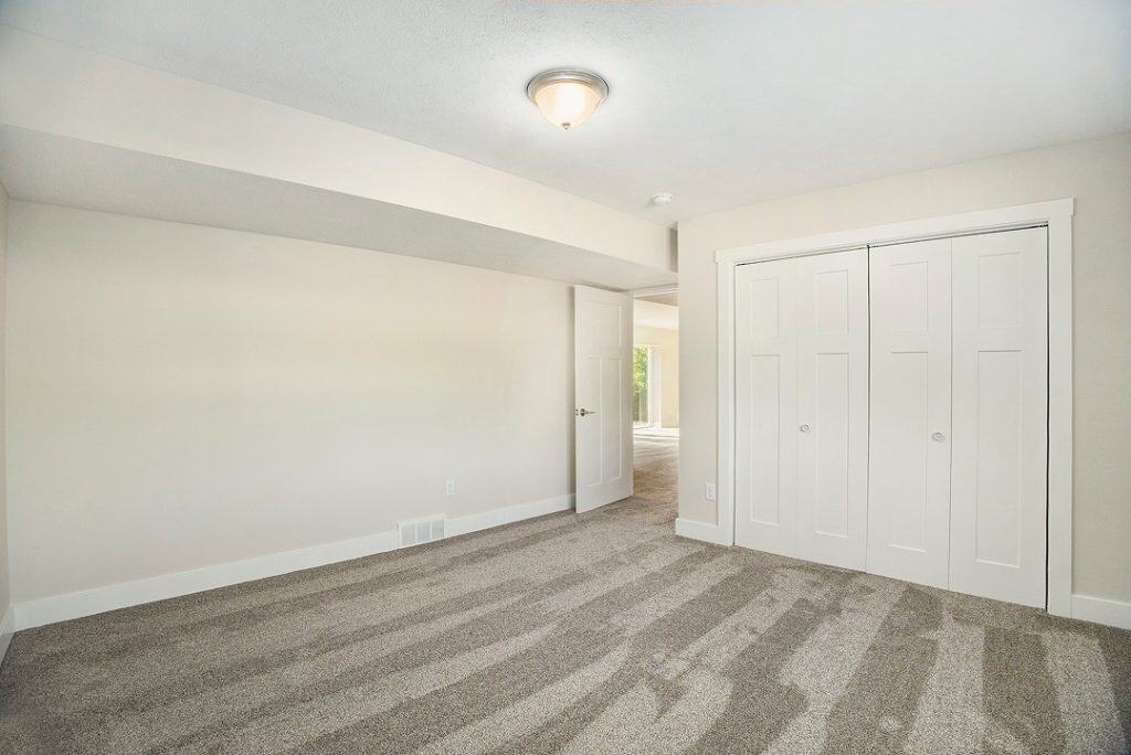 Spacious interior room with white walls and closet in a BuildWest Custom Home.
