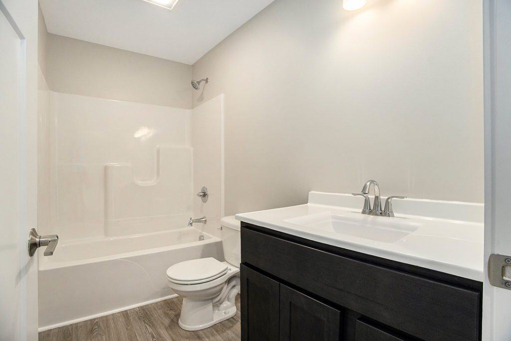 Contemporary bathroom with bathtub, toilet, and vanity in a new build.