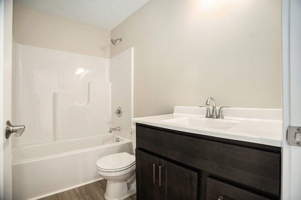 Contemporary bathroom with bathtub, toilet, and vanity in new build.