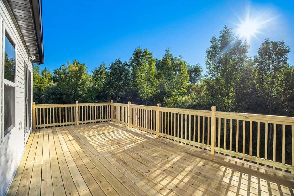 Newly built wooden deck with railing at BuildWest Custom Homes.